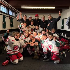 North Toronto U10 Select team celebrating their NYHL U10 Tier 1 League championship in the locker room, holding the trophy