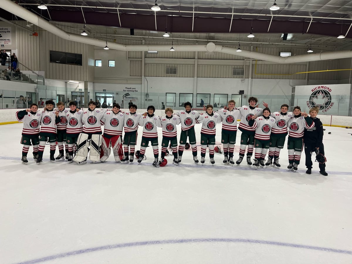 NT U14 AA team lined up on the ice celebrating tournament win