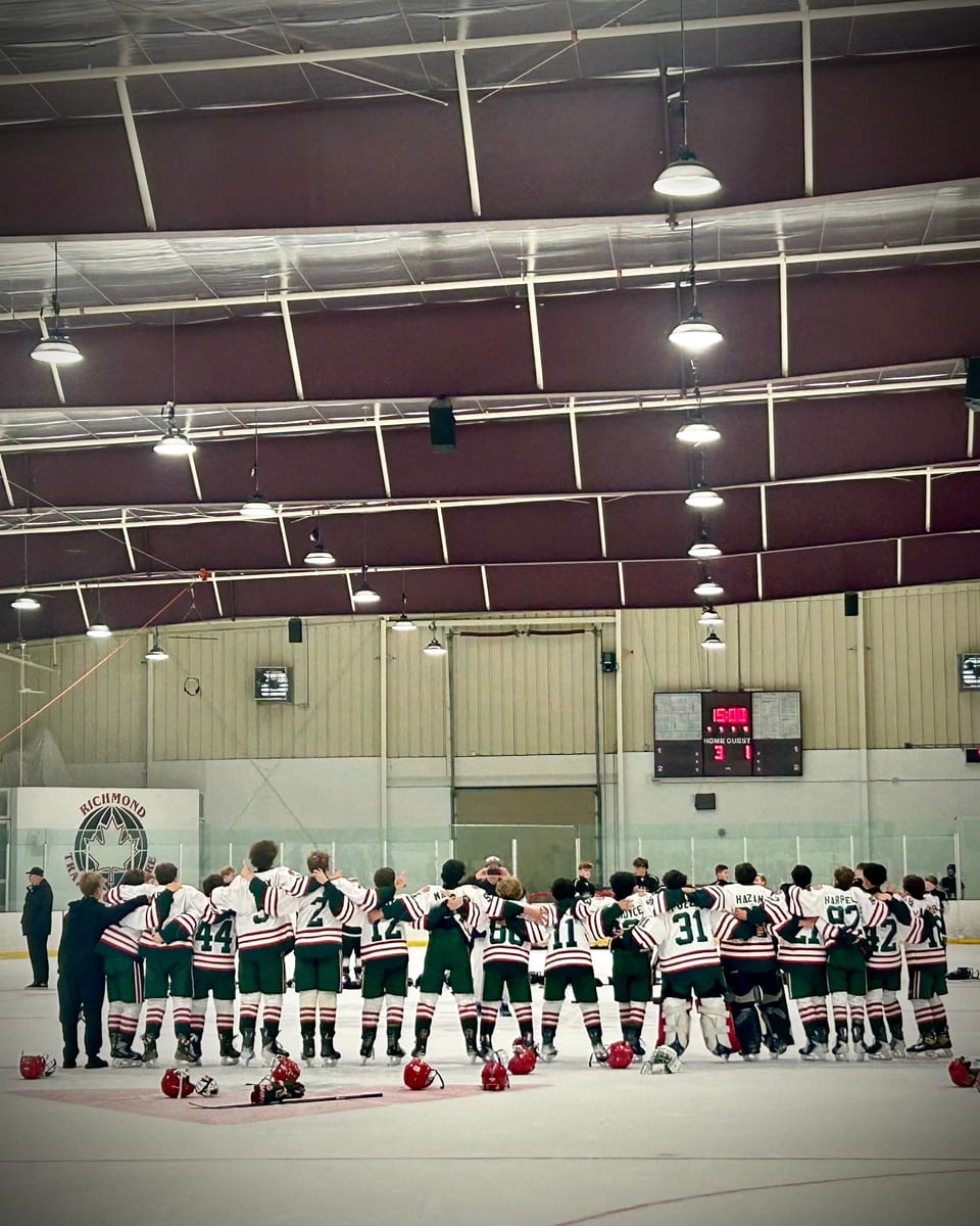 NT U14 AA team huddled together on the ice after the final game, scoreboard showing 3-1 win