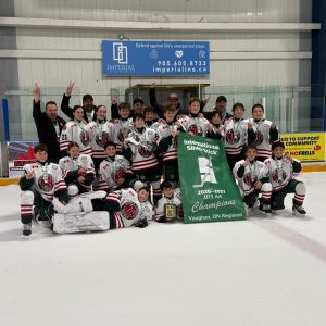 NT U13 AA team celebrating on ice with Vaughan Regional Silver Stick Championship banner and trophy