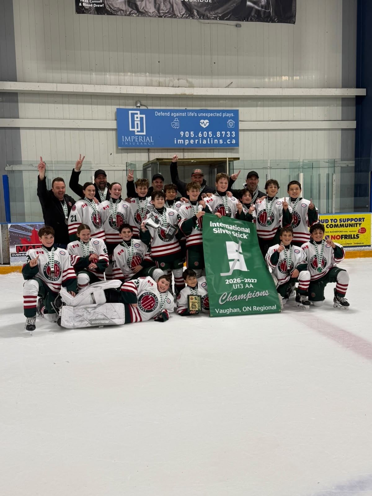 NT U13 AA team celebrating on ice with Vaughan Regional Silver Stick Championship banner and trophy