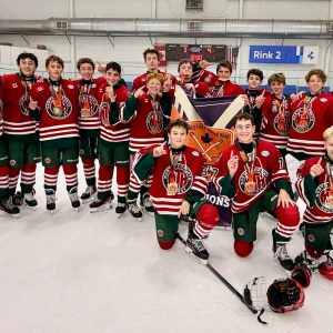 NT U15A team celebrating with medals and championship banner after winning the Avenue Road Ducks Pre-Season Faceoff tournament