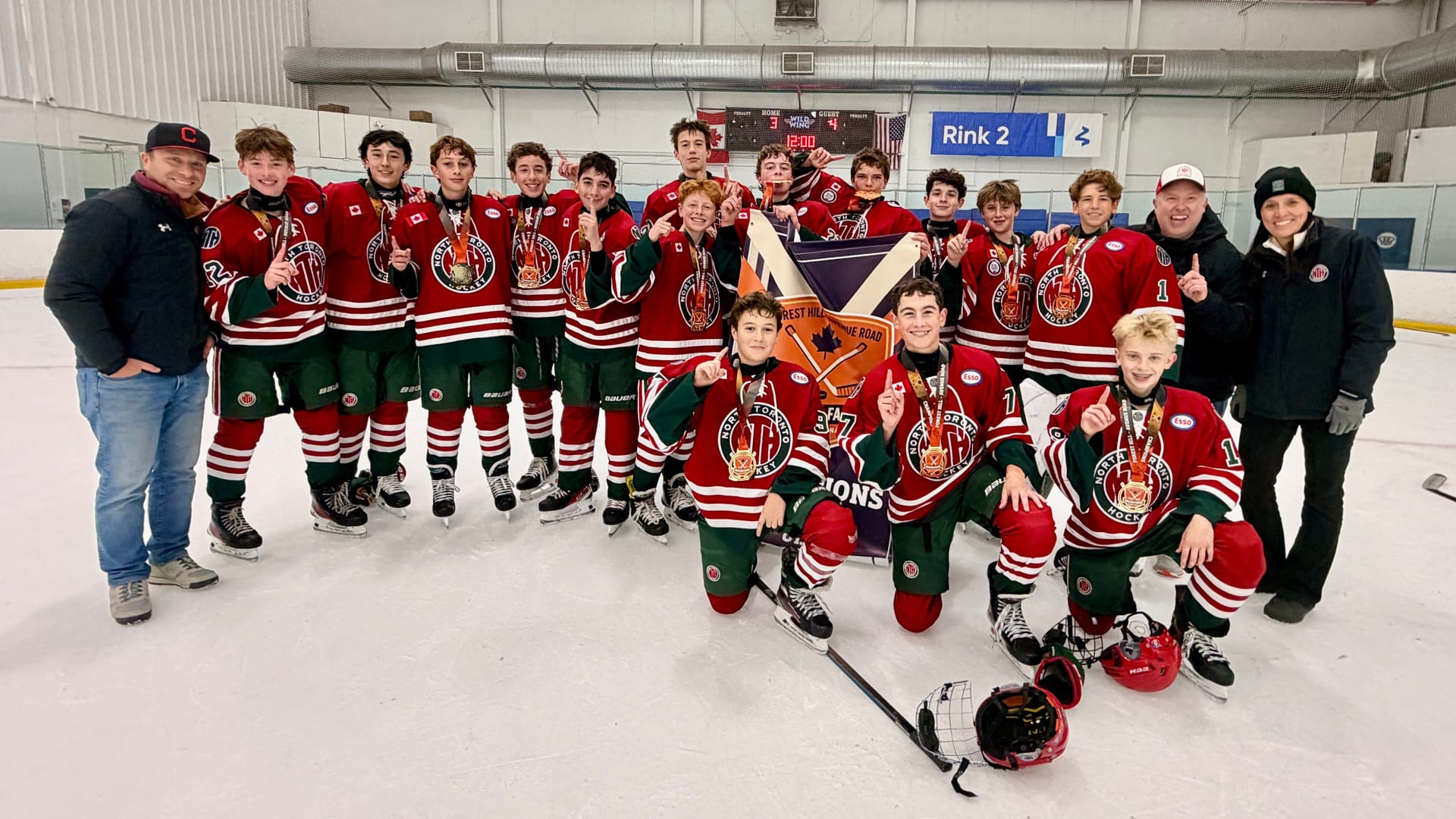 NT U15A team celebrating with medals and championship banner after winning the Avenue Road Ducks Pre-Season Faceoff tournament